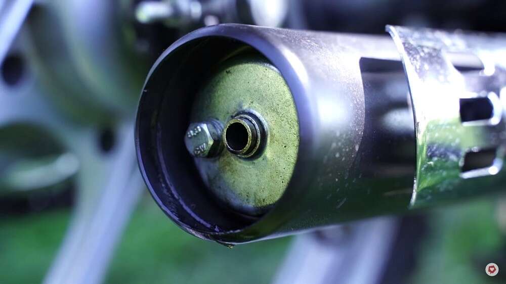 Der Schalldämpfer ist mit dem Endstück des Auspuffs verschraubt Der Schalldämpfer ist mit dem Endstück des Auspuffs verschraubt